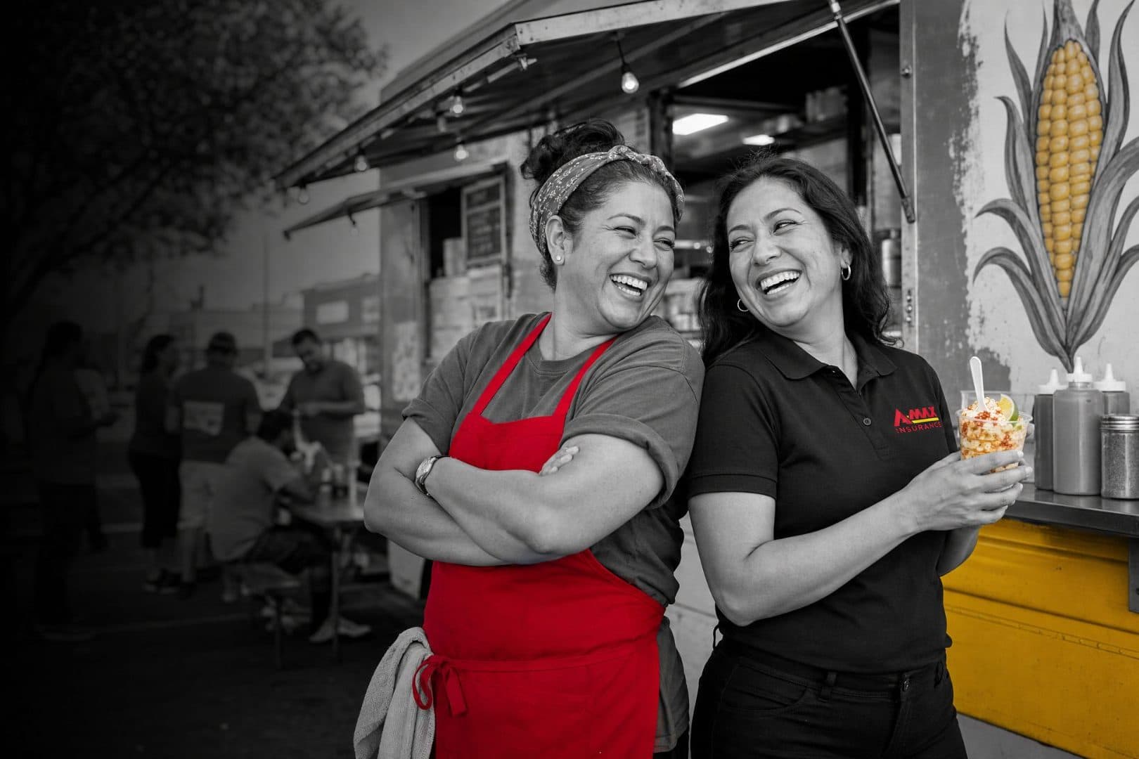 A restaurant owner in an apron smiling with an A-MAX agent