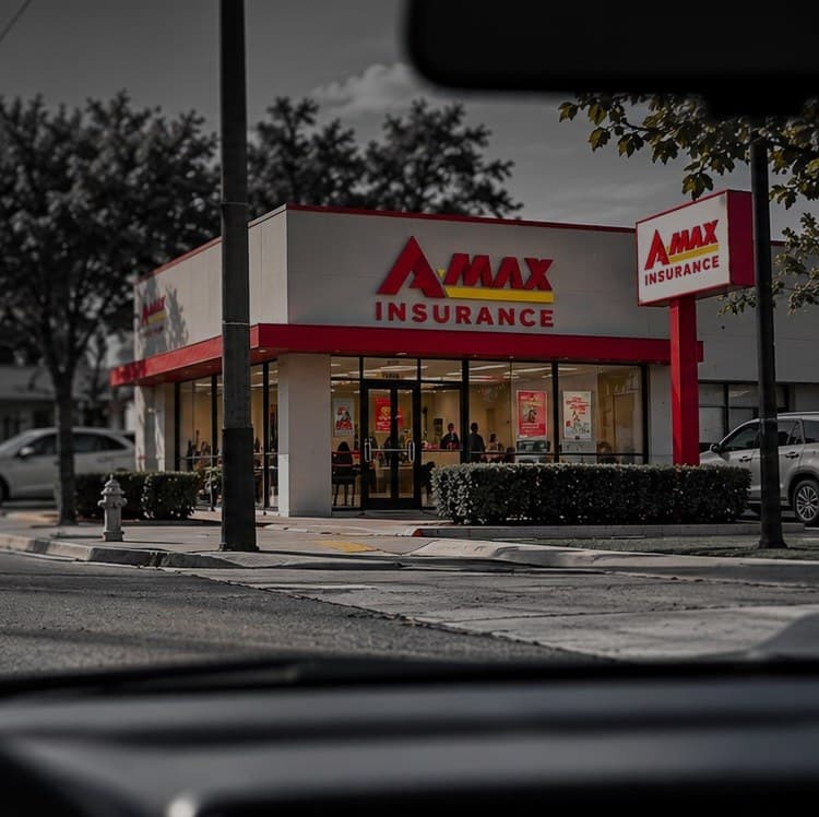 View through a car windshield of an A-MAX Insurance office down the street